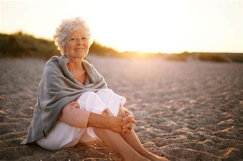 Relaxed Retired Woman Wearing Shawl Sitting On Sandy Beach Old