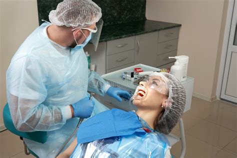 Dentist Doing A Dental Treatment On A Female Patient Dentist Examining