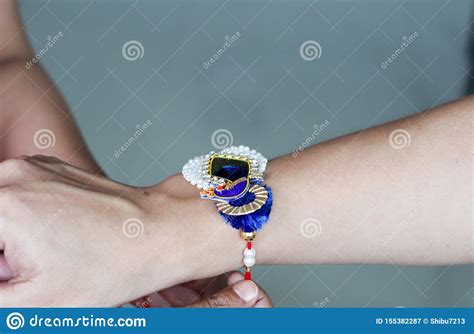 Hand Of A Lady Tying Rakhi In Hand Of A Guy During The Hindu Ritual Of Rakshabandhan With