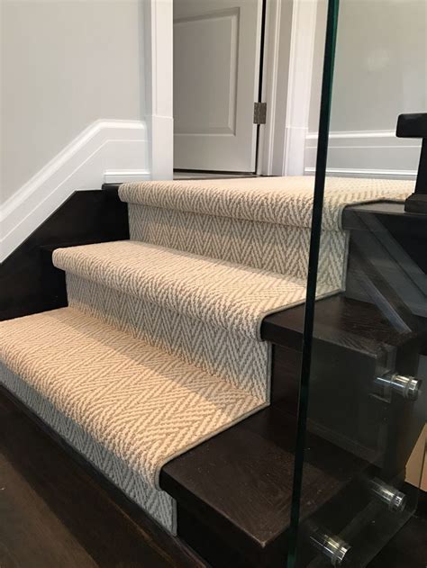 A Set Of Stairs With Carpeted Treads And Glass Railing On Each Handrail