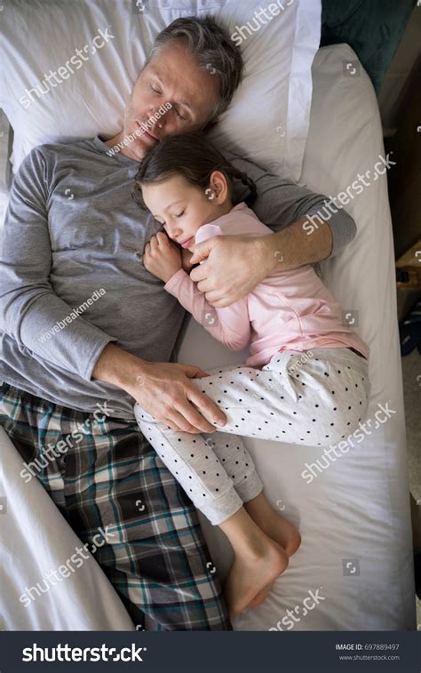 Father Daughter Sleeping Together On Bed Stock Photo