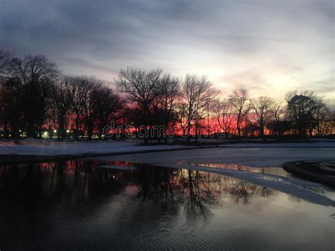 Sunset In A Park With Ice On Frozen Pond In Winter Stock