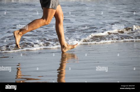 Mature Woman Running Barefoot On Beach Stock Photo Alamy