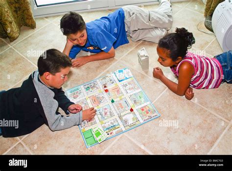 3 Ethnic Diversity Kids Boys And Girl Playing Board Game Indoor United