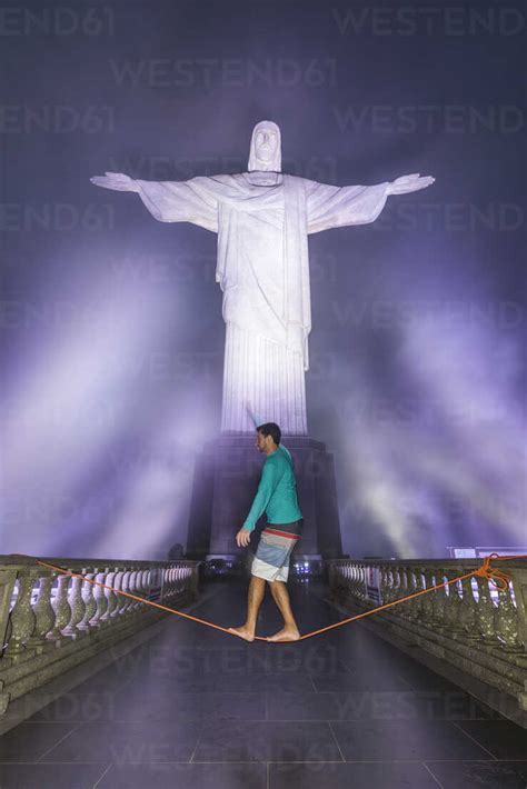 Man Slacklining Under Christ The Redeemer Statue At Night At Corcovado