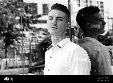 Young Handsome Man Leaning Against Glass Window Of Modern Building In