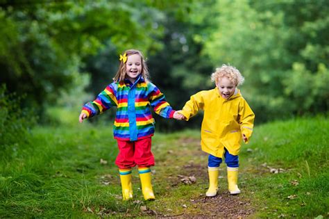 Happy Kids Playing In Mud In The Rain Stock Photo