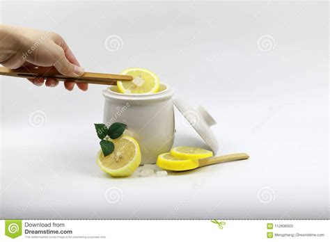 A Hand Fresh Yellow Sliced Lemon Scrub And Crystal Sugar Rock