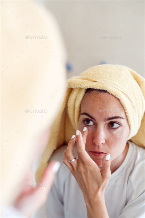 Woman In Towel After Shower Look In Mirror Apply Moisturizing Facial Cream Skincare Concept