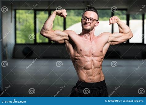 Muscular Geek Man Flexing Muscles In Gym Stock Photo Image Of Biceps