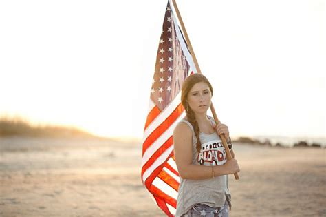 A Woman Holding An American Flag On The Beach