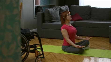 Pan Of Paraplegic Woman Sitting In Lotus Pose On Yoga Mat And