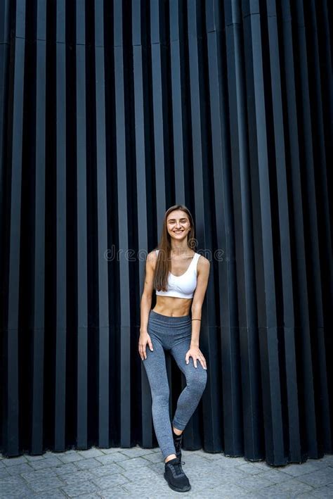 Sportive And Very Slim Woman Posing Outdoors On Abstract Background