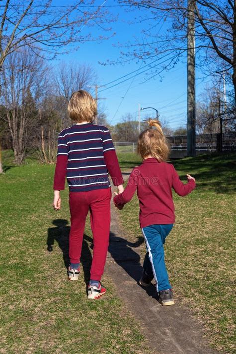 Children Walking In The Park In Spring Siblings Holding Hands Stock