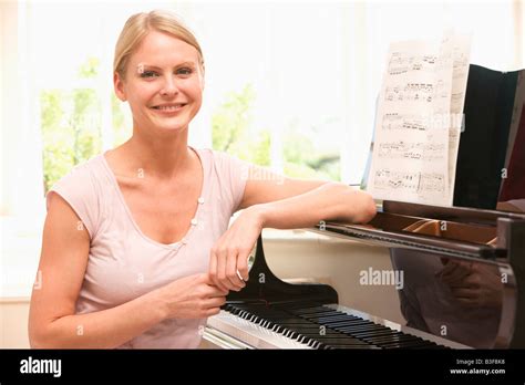 Frau am Klavier sitzen und Lächeln Stockfotografie Alamy