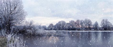 Atmospheric Winter Landscape With River Trees On The Shore Cloudy Sky