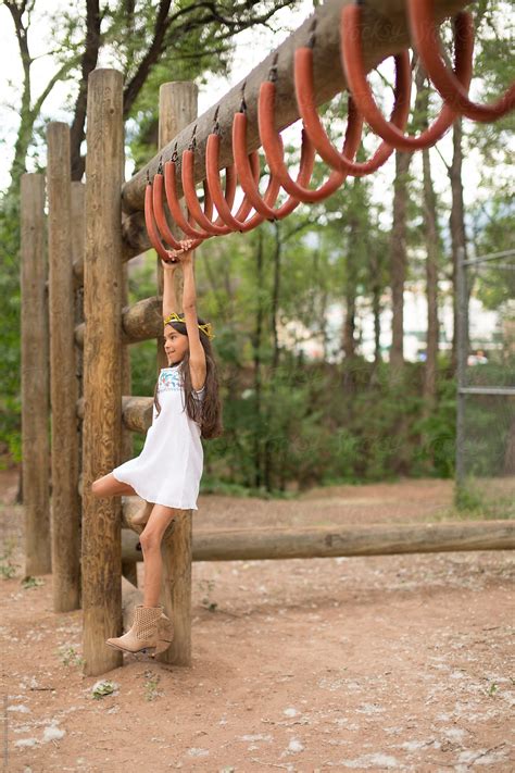 Young Girl Swinging On Monkey Bars By Gabrielle Lutze