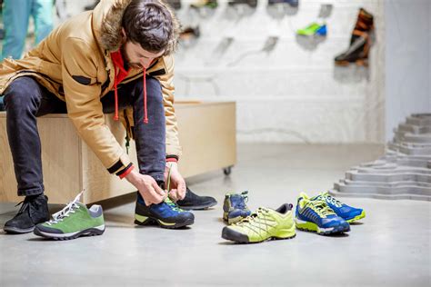Man trying shoes for hiking in the shop - Outdoor Troop