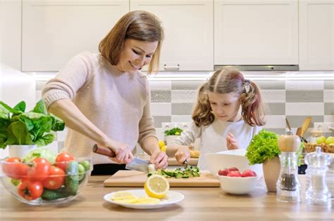 Madre E Hija Cortan Verduras En Casa En La Cocina Foto Premium