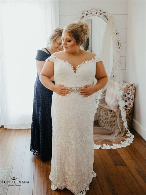 curvy bride is getting prepared for the wedding day she wears plus size full l… plus size