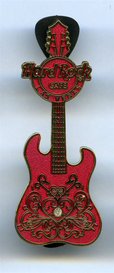 A Red And Black Guitar Shaped Brooch With An Embellishment On The Back