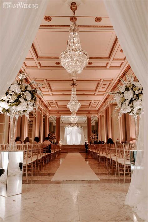 An Elegant Wedding Setup With Chandeliers And Flowers