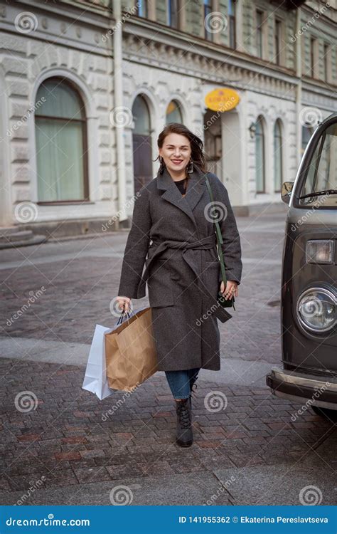 Woman Enjoys A Successful Shopping Walking Down The Street With Bags