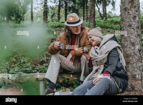 Mature Woman With Man Having Hot Tea In Forest Stock Photo Alamy