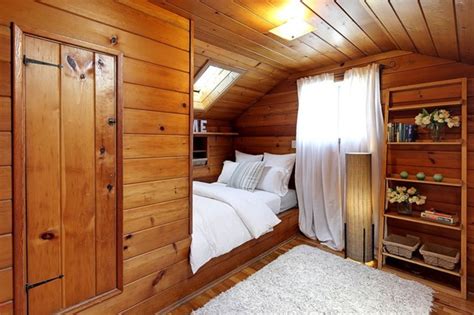 A Bedroom With Wood Paneling And White Bedding In An Attic Style Room