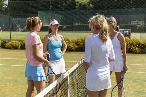 Mature Women Finishing Tennis Match On Grass Court Stock Photo