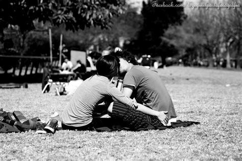 Two People Are Sitting On The Grass In A Park