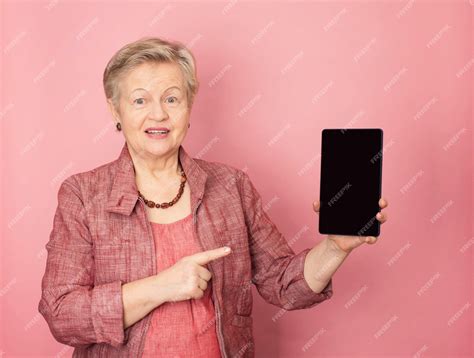 Premium Photo Mature Woman Showing A Tablet Computer And Smiling On