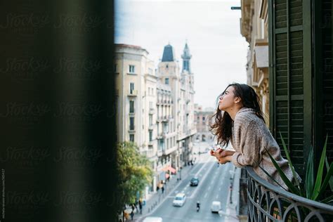 Young Woman Leaning On The Balcony Of Her House By Michela Ravasio