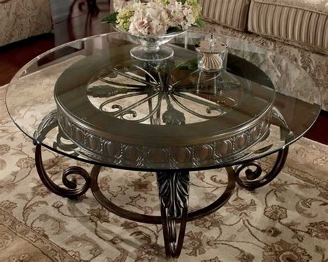 Clear Round Glass Top Coffee Table With Ornate Brown Base Placed In A