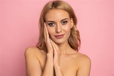 image of adorable half naked woman smiling at camera and touching her face isolated over pink