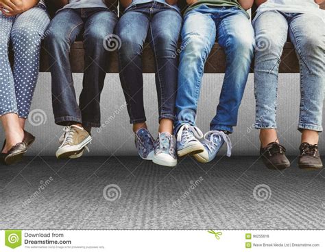 Group Of People S Legs Sitting On Bench In Front Of Grey Background
