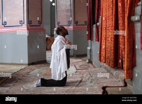 An Ethiopian Orthodox Worshipper Kneels In Prayer Inside The Ethiopian