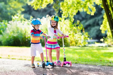 As soon as you grab a hold of it. Kids Riding Scooter In Summer Park. Stock Photo - Image of ...