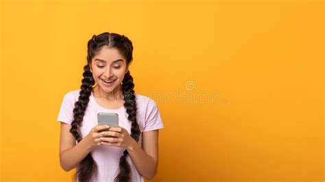 Indian Woman Using Smart Phone Isolated On Yellow Background Stock