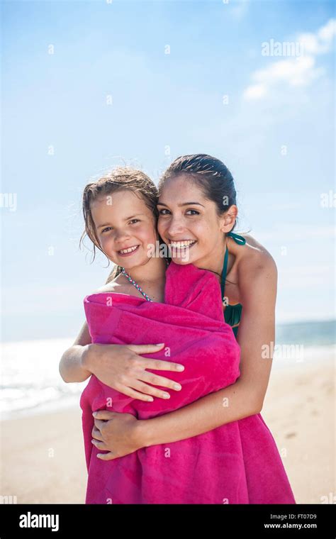 Lovely Mom At The Beach Wrapping Her Little Girl In A Towel After Bath