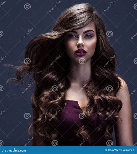 face of a beautiful woman with long brown curly hair fashion model with wavy hairstyle stock
