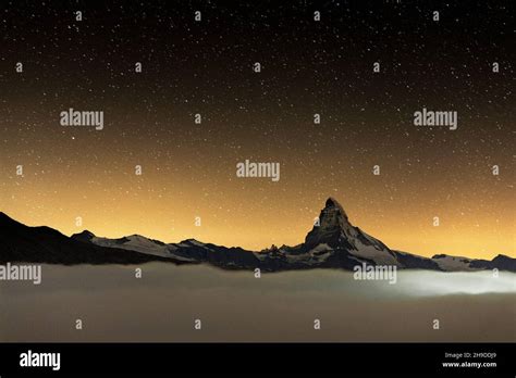 Romantic Night Sky With Stars Over Matterhorn Emerging From Fog