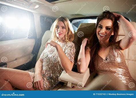 Two Glamorous Women Relax In The Back Of A Limo In Car View Stock