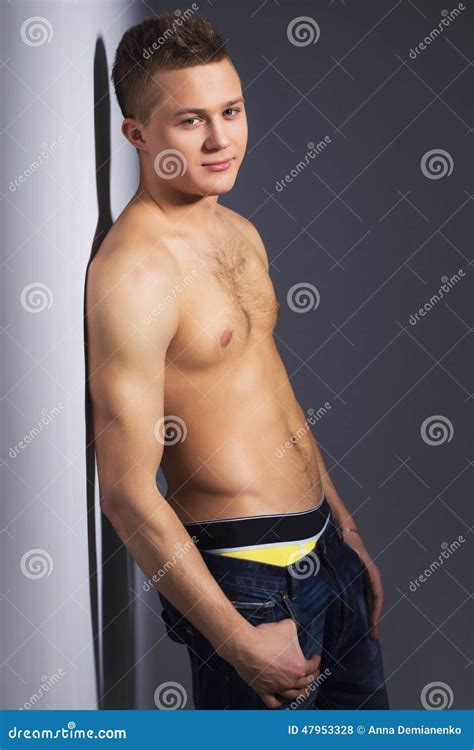 Shirtless Handsome Man With Fit Body Lean Against A Wall Stock Photo