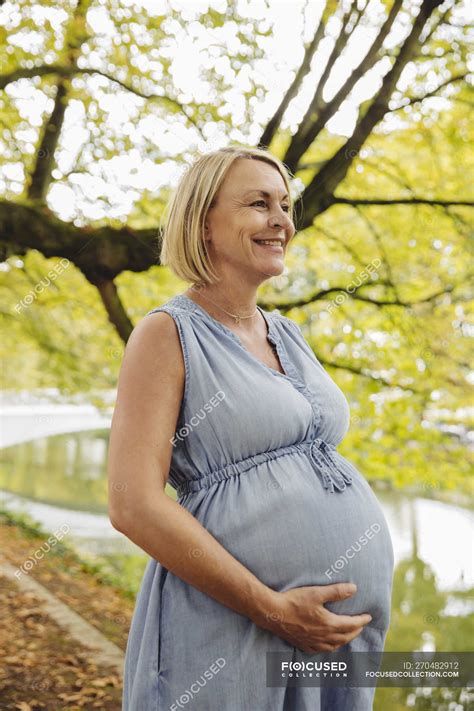 Happy Mature Pregnant Woman Standing In Park — People Casual Stock