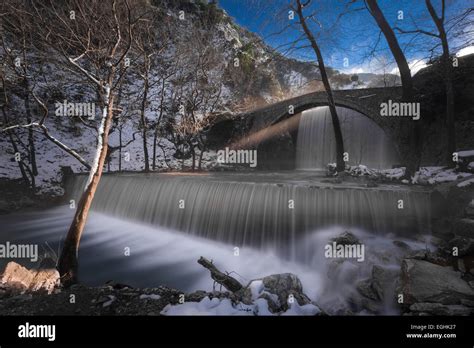 Double Waterfall Flowing Under An Arched Stone Bridge Stock Photo Alamy