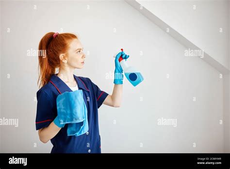 Beautiful Red Haired Housewife Wearing Household Rubber Gloves And Blue Dressing Gown Looking At