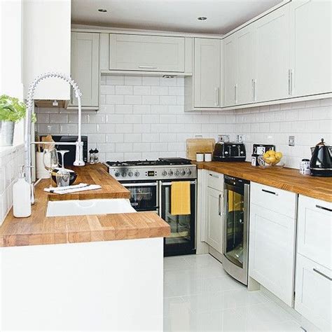 Too much of anything can make a space feel claustrophobic. White kitchen with wooden worktops and metro tiles ...