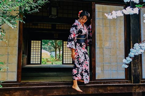 Woman In Black White And Red Floral Kimono Standing On Brown Wooden