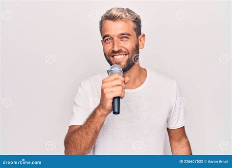 Handsome Blond Singer Man With Beard Singing Song Using Microphone Over White Background Looking